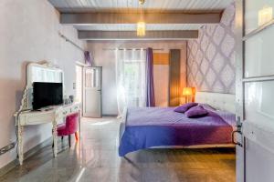 a bedroom with a bed and a desk and a tv at Côté Cour in Rasteau +28 photos