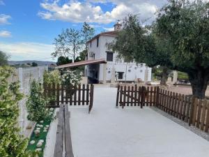 a fence in front of a house with a building at Casa de Antonio con piscina privada in Moratalla
