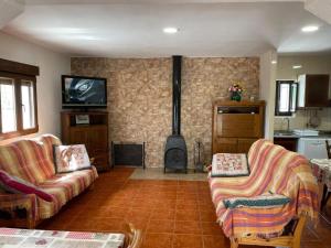 a living room with two couches and a stove at Casa de Antonio con piscina privada in Moratalla