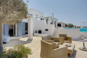 a view of a villa with chairs and a pool at Blueros - Black Stone Suite in Megas Gialos - Nites +17 photos