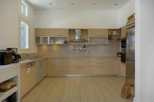 a large kitchen with wooden cabinets and stainless steel appliances at Blueros - Black Stone Suite in Megas Gialos - Nites