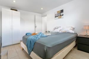 a bedroom with a large bed and white walls at Beach House el Poris 2 in Poris de Abona