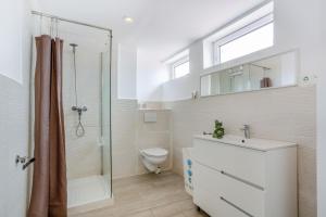a bathroom with a toilet and a shower and a sink at Beach House el Poris 2 in Poris de Abona +13 photos