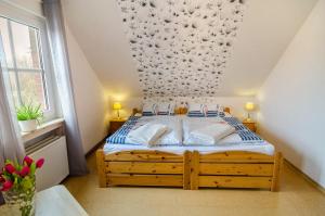 a bedroom with a bed with a floral wall at Ferienwohnung Utkiek in Ihlow