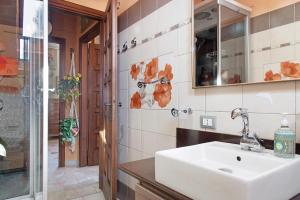 a bathroom with a sink and a mirror at L'attico Con Terrazza Vista Lago in Laveno-Mombello +25 photos