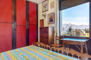 a bedroom with a bed and a table and a window at L'attico Con Terrazza Vista Lago in Laveno-Mombello