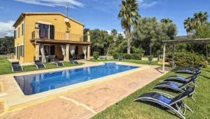 a villa with a swimming pool in front of a house at Ines in Inca