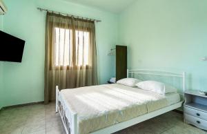a bedroom with a white bed and a window at Old Boat double studio 5 in Nikiana