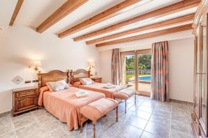 a bedroom with two beds and a balcony at Casa Del Pinaret in Port de Pollensa