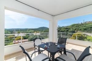 a patio with a table and chairs on a balcony at Casa Virgi vista mare in Budoni