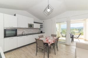 a kitchen and dining room with a table and chairs at Casa Virgi vista mare in Budoni