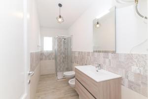 a bathroom with a sink and a toilet and a shower at Casa Virgi vista mare in Budoni +14 photos