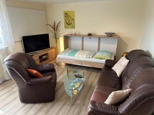 a living room with a couch and chairs and a bed at Ferienwohnung Taunusnest in Limbach