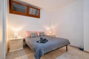 a bedroom with a bed with two night stands and two windows at Soleluna apartment in Castelsardo +18 photos