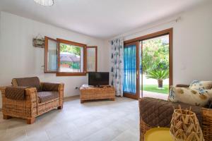 a living room with a couch and a tv and chairs at Soleluna apartment in Castelsardo