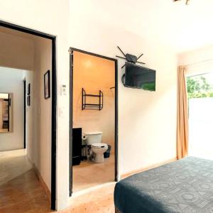 a bedroom with a door leading to a bathroom with a toilet at Casa Maya Villa with Private Pool Bar and Parking Merida in Mérida