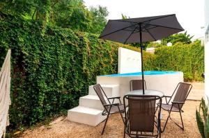 a table and chairs with an umbrella on a patio at Casa Maya Villa with Private Pool Bar and Parking Merida in Mérida