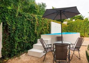 a table and chairs with an umbrella on a patio at Casa Maya Villa with Private Pool Bar and Parking Merida in Mérida