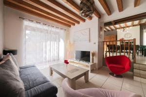 a living room with a couch and a red chair at Gite Cours Péan in Châteaugiron