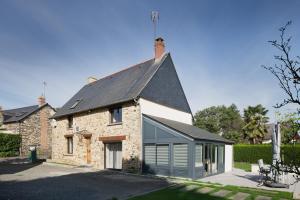 an old stone house with a black roof at Gite Cours Péan in Châteaugiron