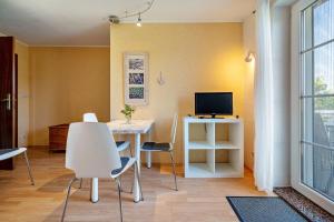 a living room with a table and chairs and a television at Ferienwohnung 1 Schulze in Neustrelitz