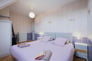 a bedroom with a large white bed with pink pillows at Gite Cours Péan in Châteaugiron