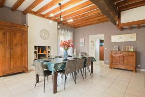 a dining room table with chairs and a vase of flowers at Gite Cours Péan in Châteaugiron
