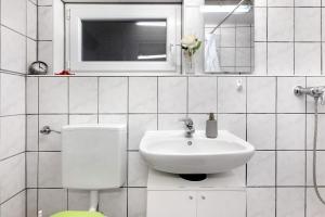 a white bathroom with a sink and a toilet at Sleep And Go in Mundelsheim