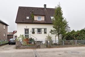 a white house with a black roof at Sleep And Go in Mundelsheim