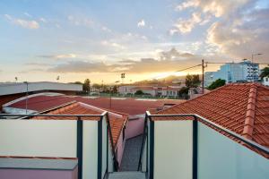 a view of roofs in a city at sunset at Alegria Dream Home in Funchal
