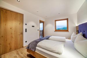 a bedroom with two beds and a wooden door at Huetterhof Apartement Winter in Caines