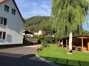 a yard with a umbrella and a table and a building at Apartmenthaus Pastner am Teich in Übelbach
