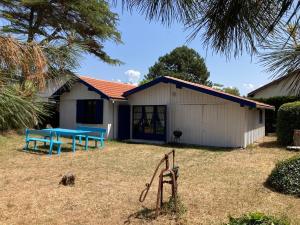 a building with a blue picnic table in the yard at Quartier des Pecheurs - Réf 35 in Lège-Cap-Ferret +3 photos