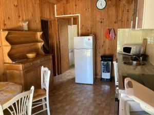 a kitchen with a white refrigerator and a sink at Quartier des Pecheurs - Réf 35 in Lège-Cap-Ferret