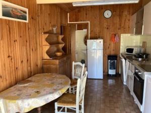 a kitchen with a table and a white refrigerator at Quartier des Pecheurs - Réf 35 in Lège-Cap-Ferret