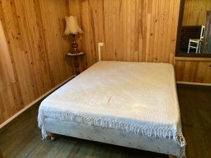 a bedroom with a bed in a room with wooden walls at Quartier des Pecheurs - Réf 35 in Lège-Cap-Ferret