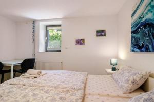 a bedroom with a bed and a desk and a window at Blauer Seestern in Allensbach