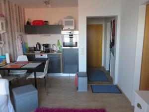 a small kitchen and dining room with a table at Kleine Seenadel in Dornumersiel +8 photos