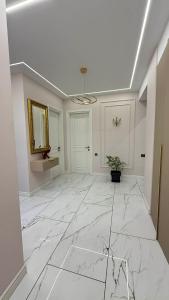 a large white room with a marble floor and a mirror at Boulevard Apartments in Itʼkhvisi