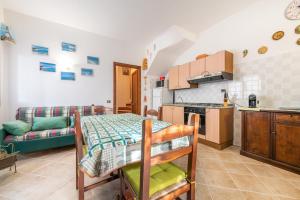 a kitchen and living room with a table and a couch at Maya in Villasimius
