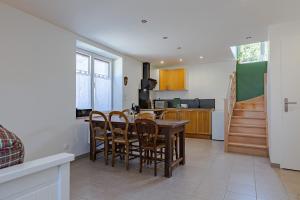 a kitchen with a table and chairs in a room at L'Arche aux Peyruches in Assieu