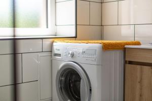 a white washing machine in a kitchen next to a counter at L'Arche aux Peyruches in Assieu