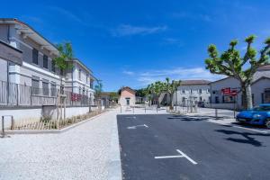 a street in a town with a car on the road at L'Arche aux Peyruches in Assieu