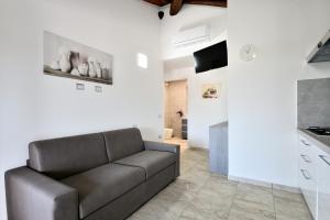 a living room with a couch and a kitchen at Pasquale Home Holiday in Bari Sardo