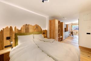 a bedroom with a large bed with a wooden headboard at Apartments Schlernheim in Fie allo Sciliar