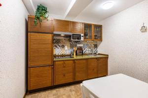 a kitchen with wooden cabinets and a counter top at Haus am Markt Fewo 3 in Schöningen