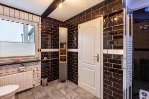 a bathroom with black tiled walls and a white door at Haus am Markt Fewo 3 in Schöningen +12 photos
