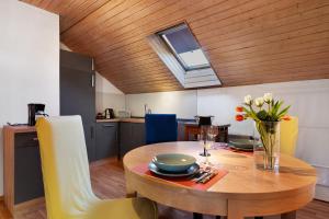 a kitchen and dining room with a wooden ceiling at Ferienwohnung Schöne Aussicht in Gemmrigheim
