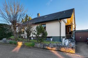 a white house with a black roof at Ferienwohnung Schöne Aussicht in Gemmrigheim