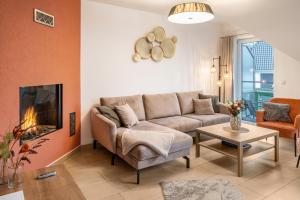 a living room with a couch and a fireplace at Domizil Eden - Obergeschoss in Göhren-Lebbin